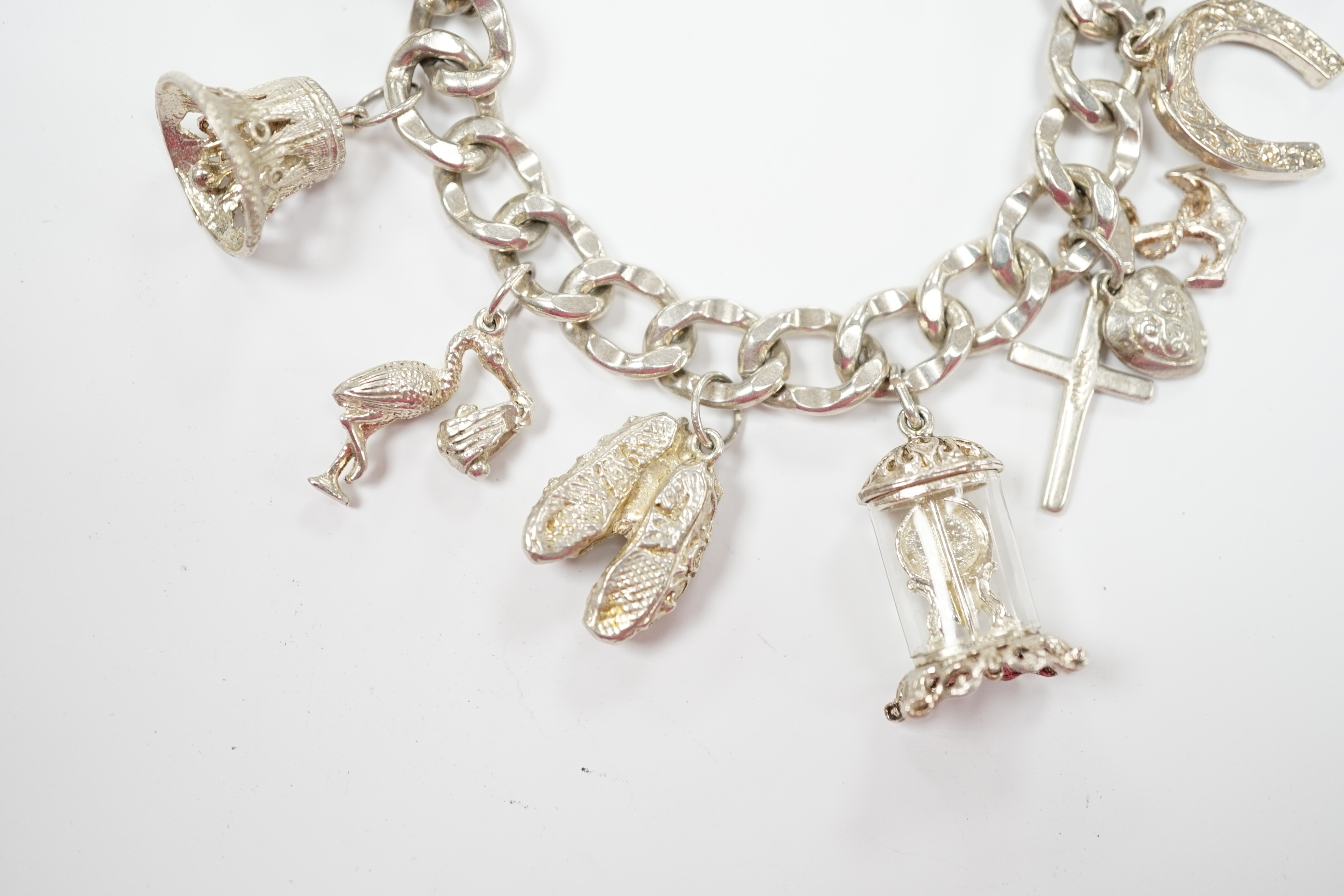 A modern silver charm bracelet, hung with nine assorted charms.